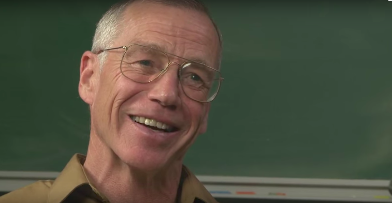 Michael Freedman smiling in front of a chalkboard