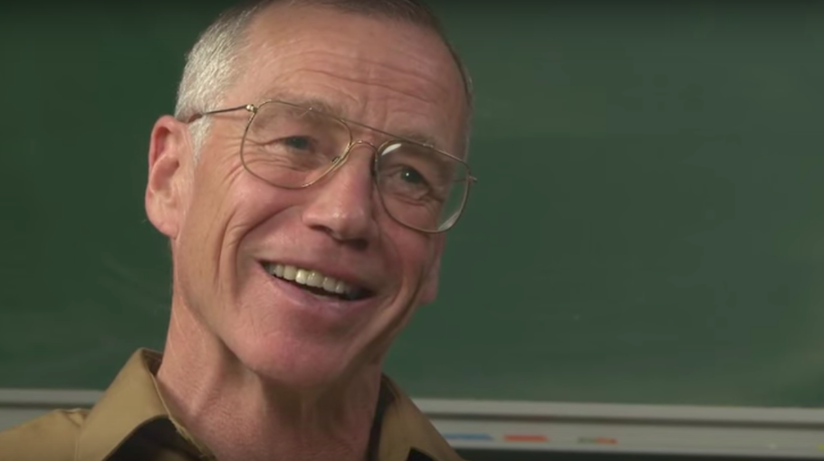 Michael Freedman smiling in front of a chalkboard