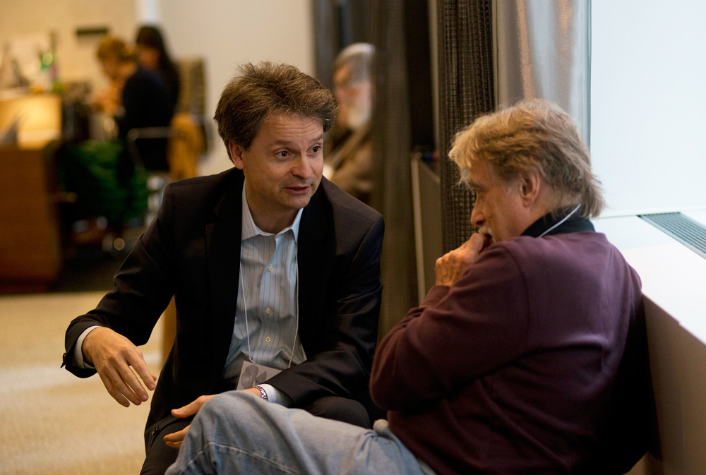 Two people sitting by a window and talking