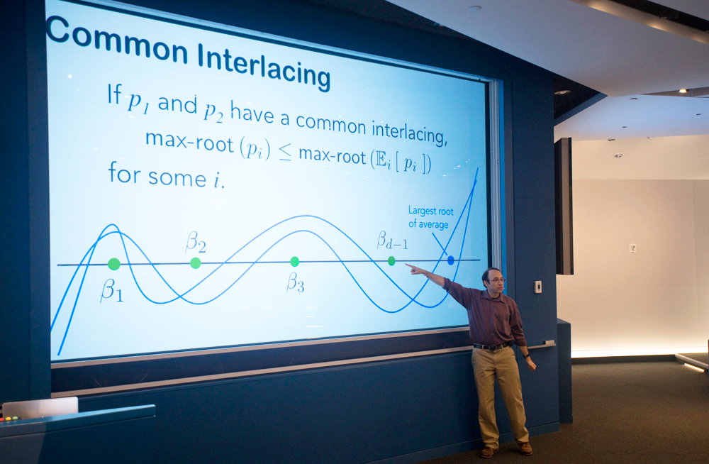 Man presenting a slideshow titled Common Interlacing