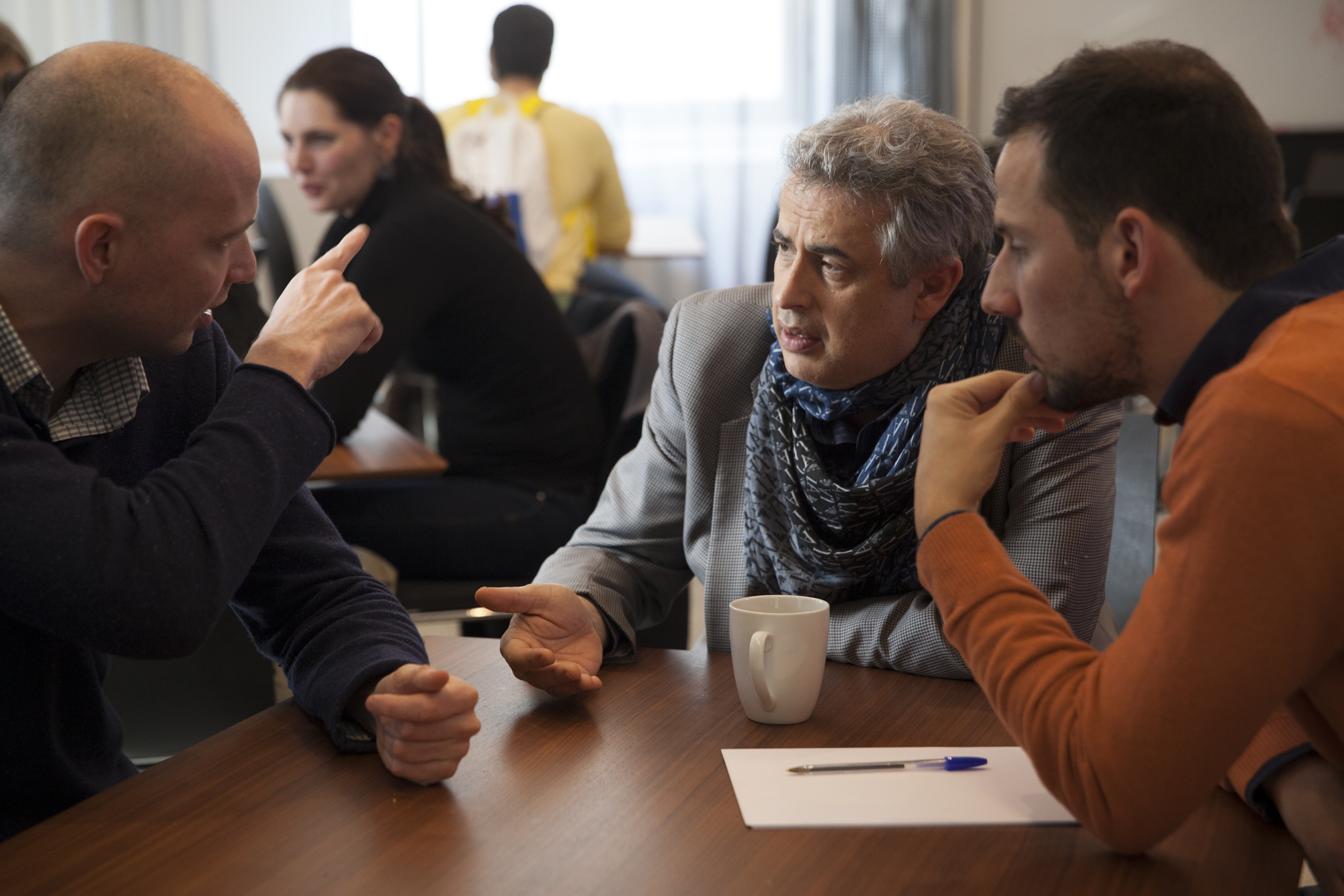 Three people sitting at a table and talking