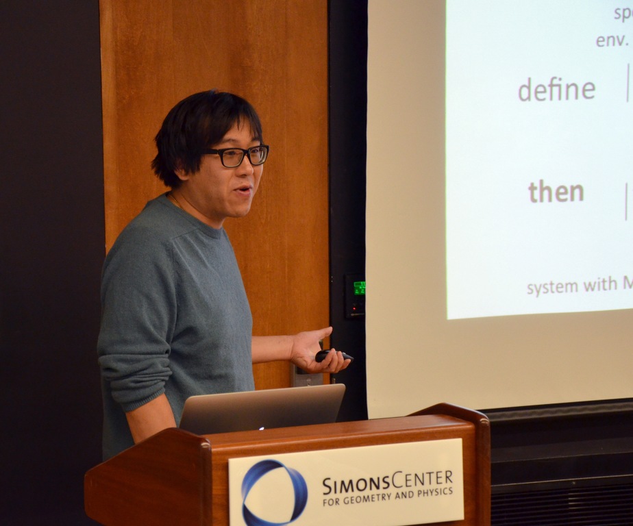 Man standing behind a lectern that says Simons Center for Geometry and Physics