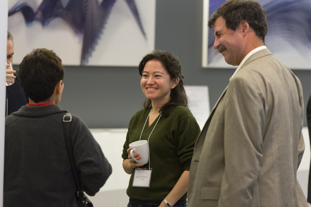 Three people standing and smiling at each other