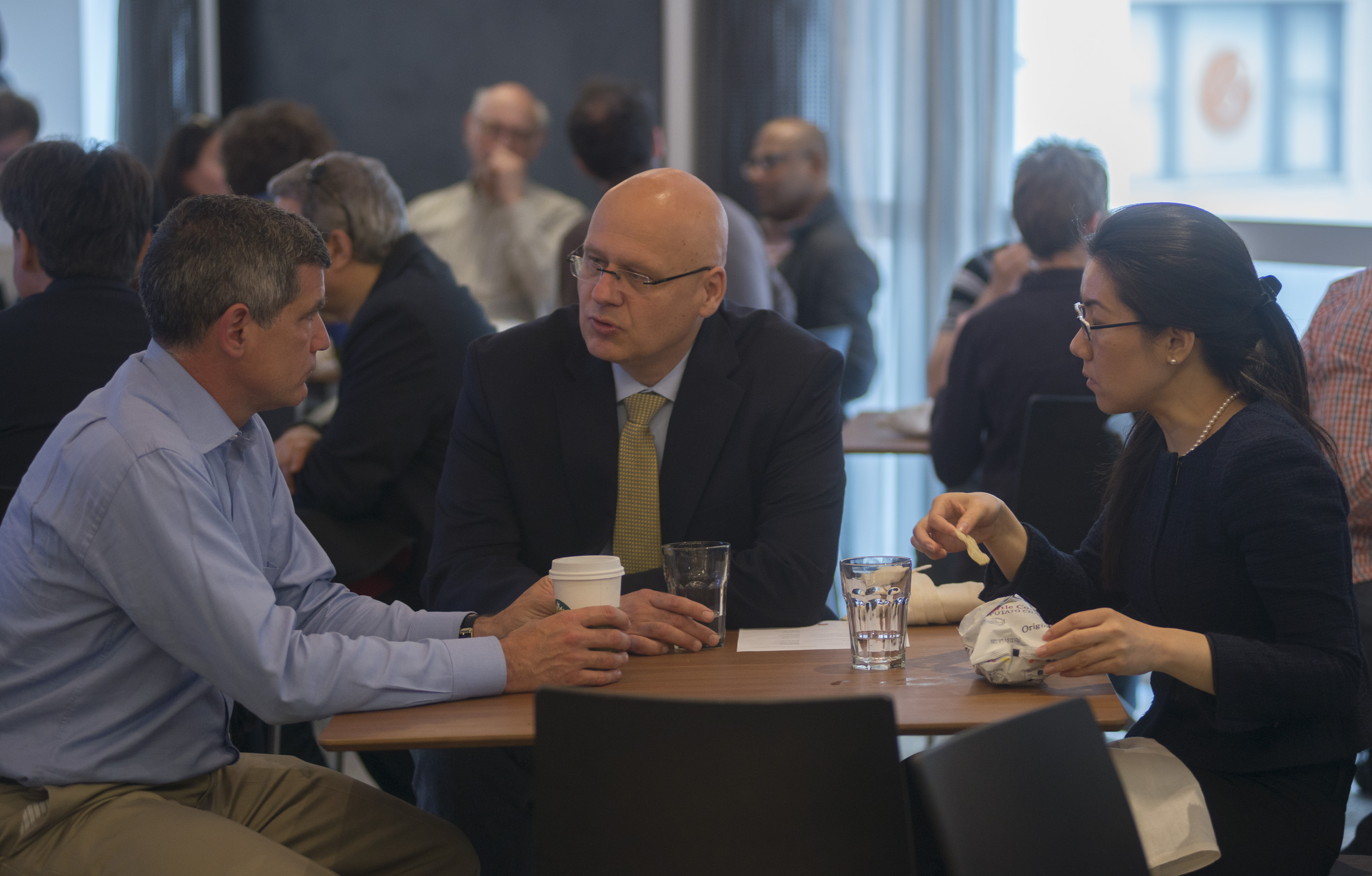 Three people sitting at a table and talking
