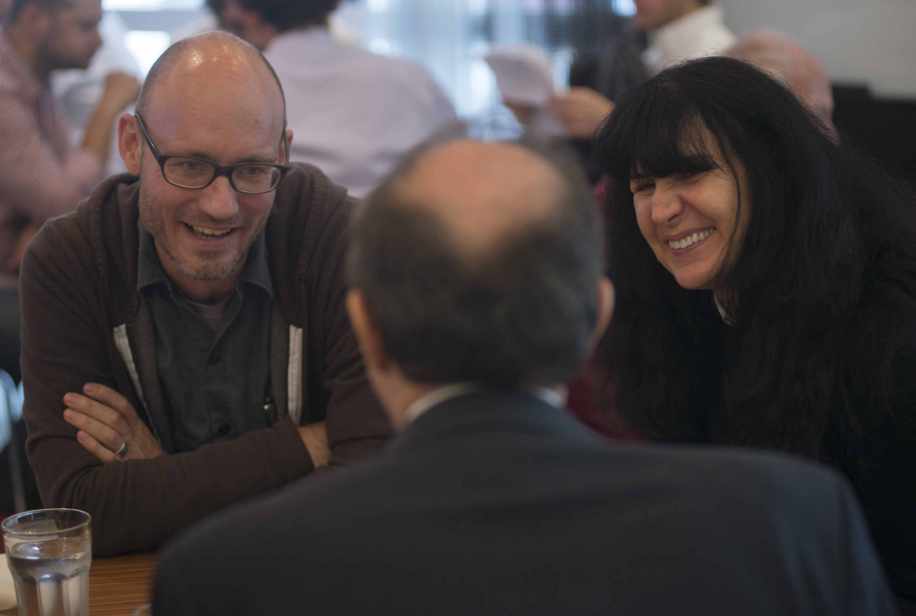 Three people sitting at a table and laughing