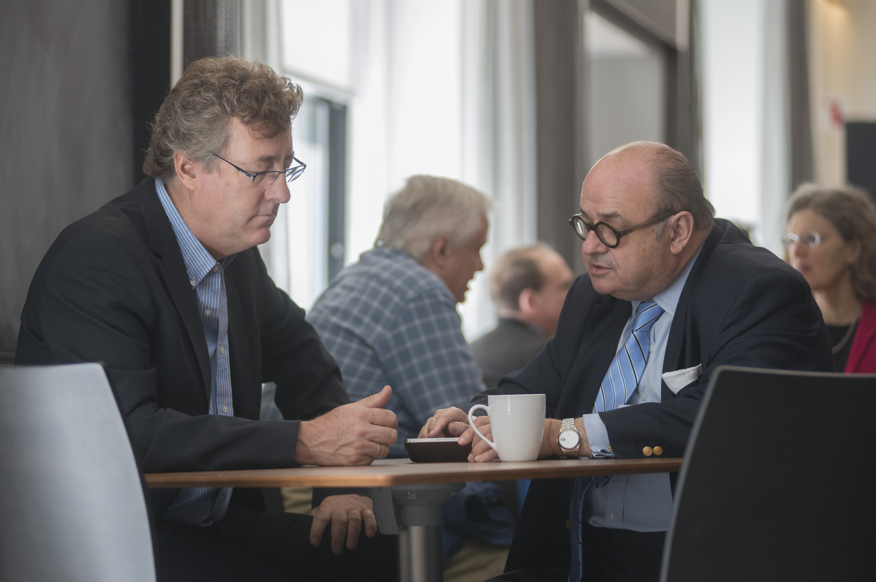 Two men sitting at a table and talking