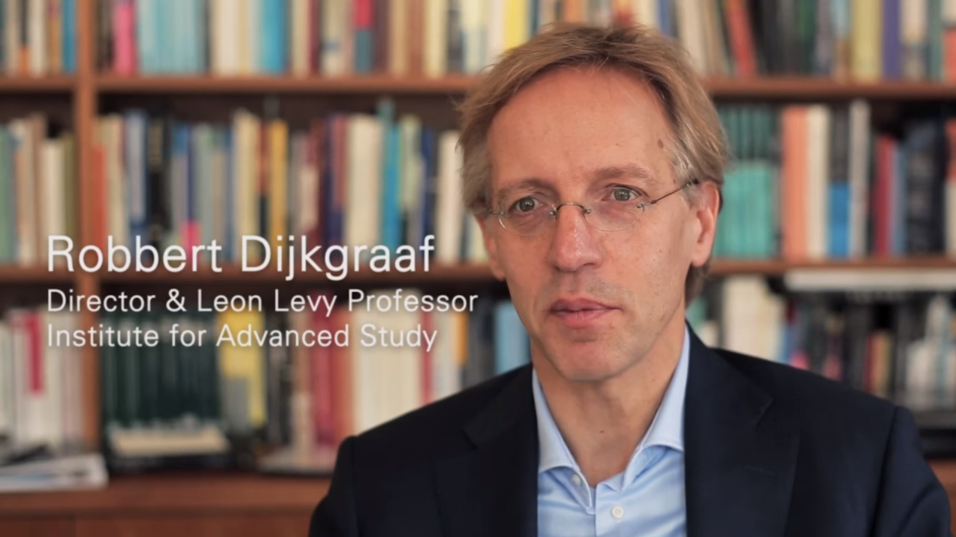 Robbert Dijkgraaf, the Director and Leon Levy Professor at the Institute for Advanced Studies, sits in front of a bookshelf