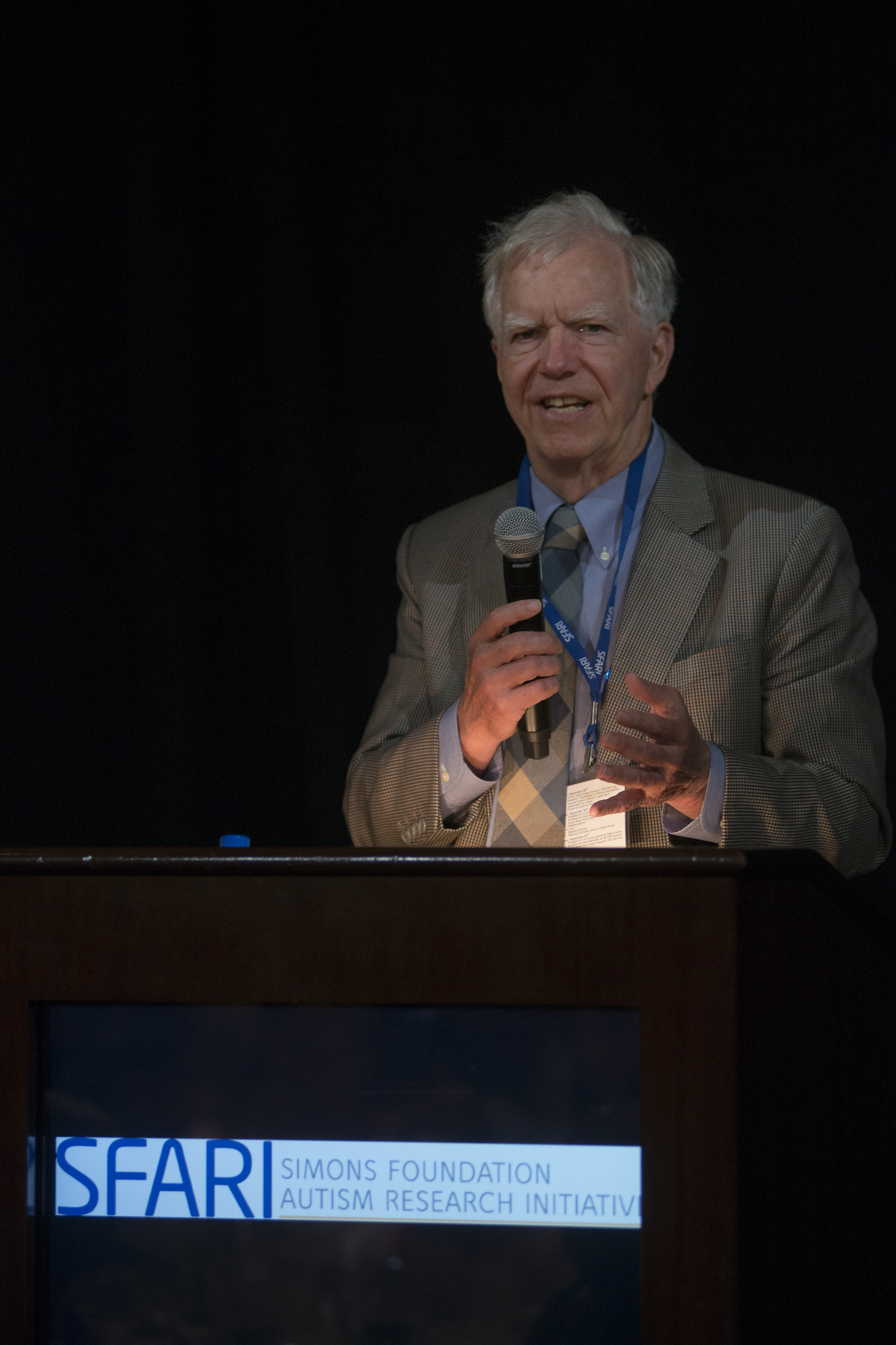 Man talking behind a lectern that says SFARISimons Foundation Autism Research Initiative