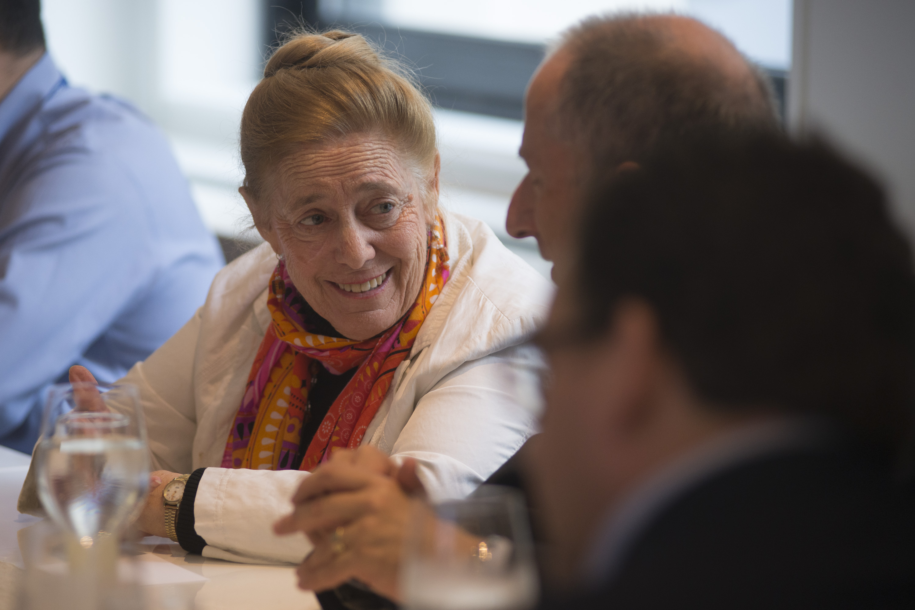 Woman and man sitting and talking amid a crowd of people