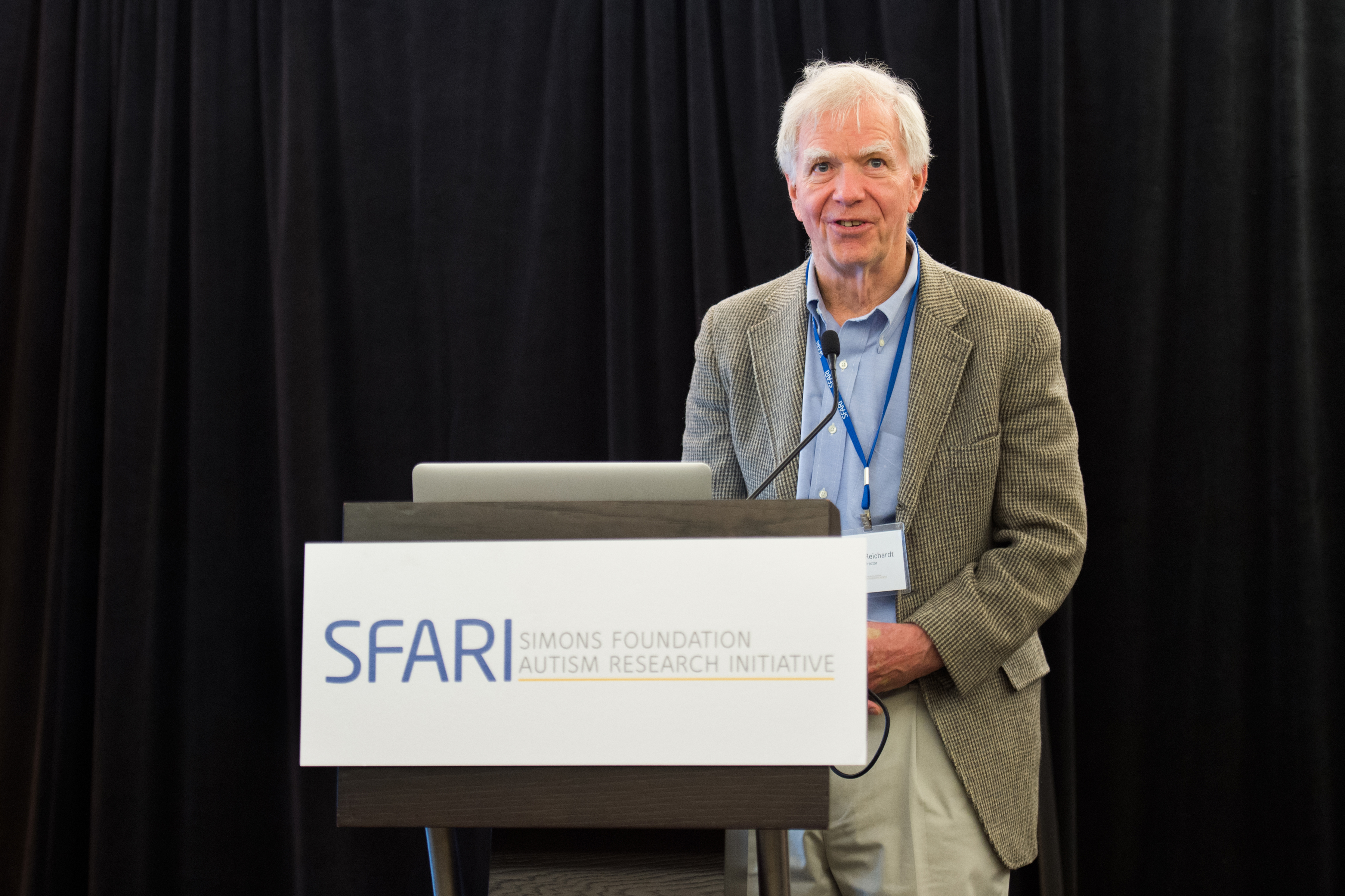 Man standing behind a lectern that says 