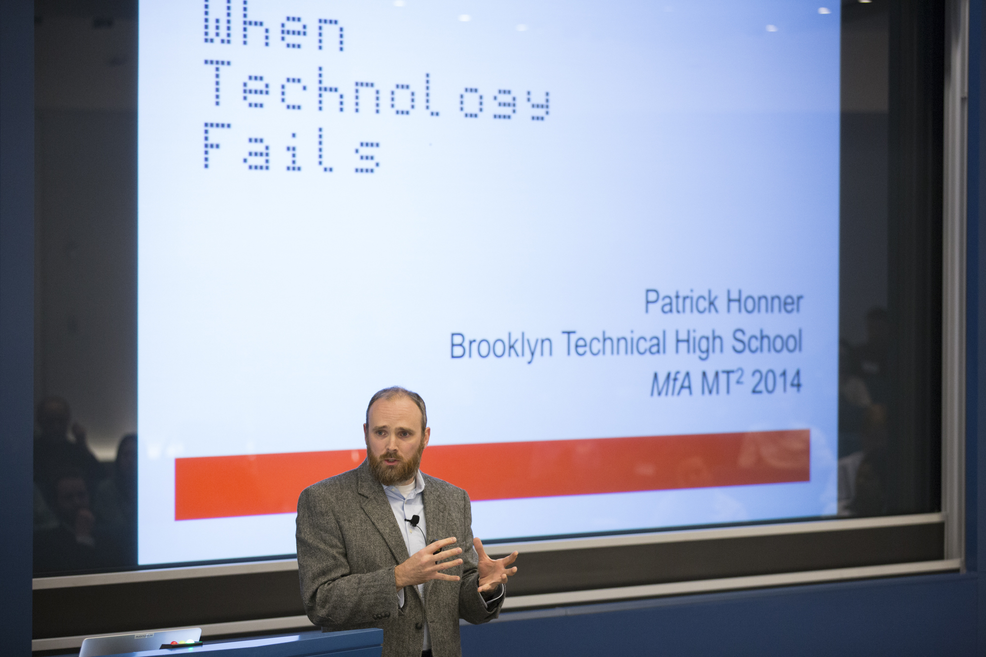 Man talking in front of a presented slideshow that says 