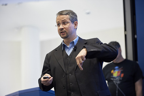 Man standing while pointing his left hand down