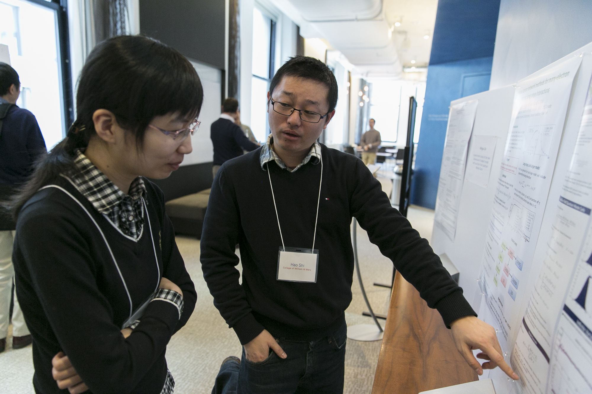 Person pointing to a presentation as someone watches