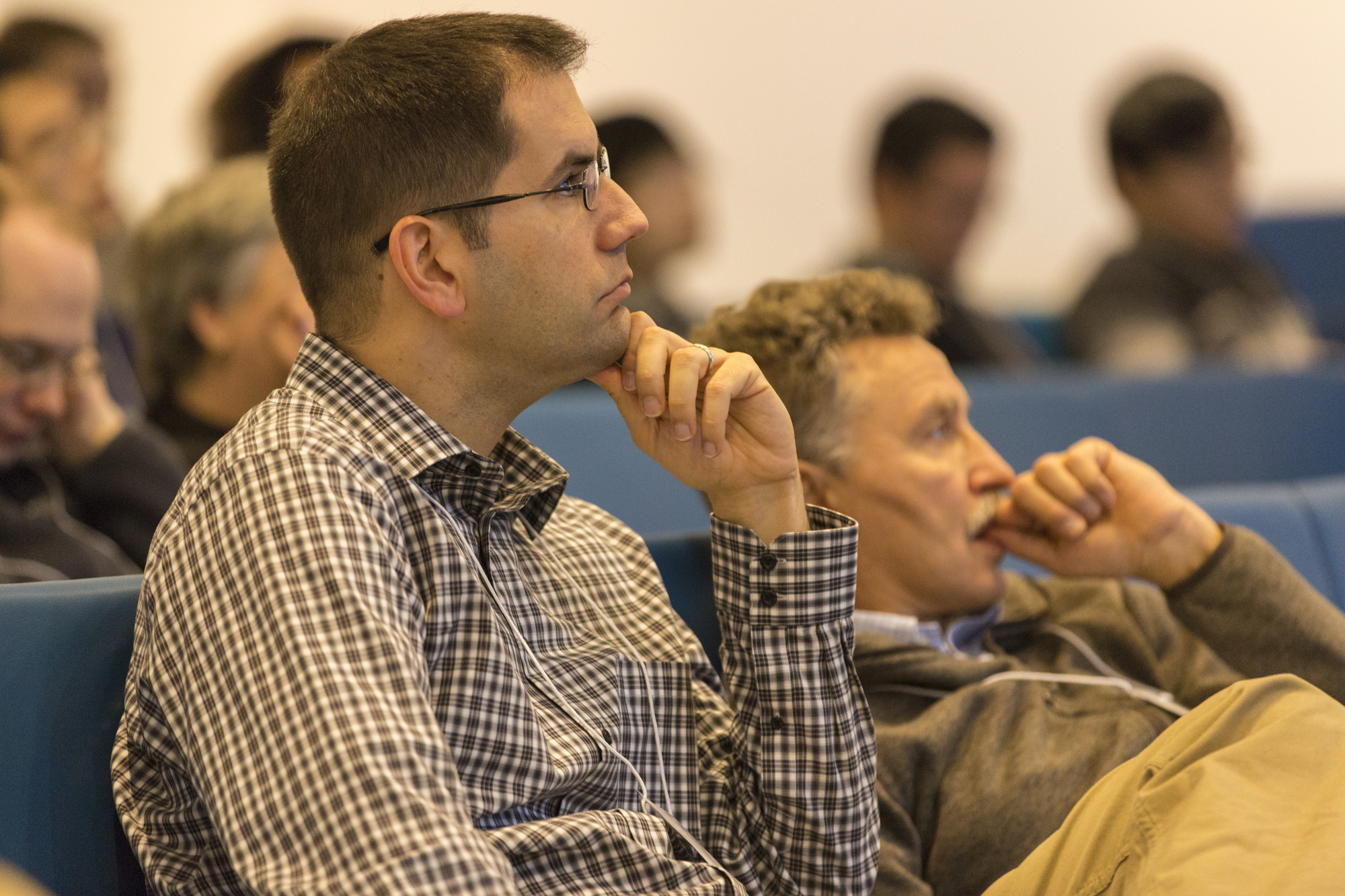 Two men sitting next to each other in a lecture hall