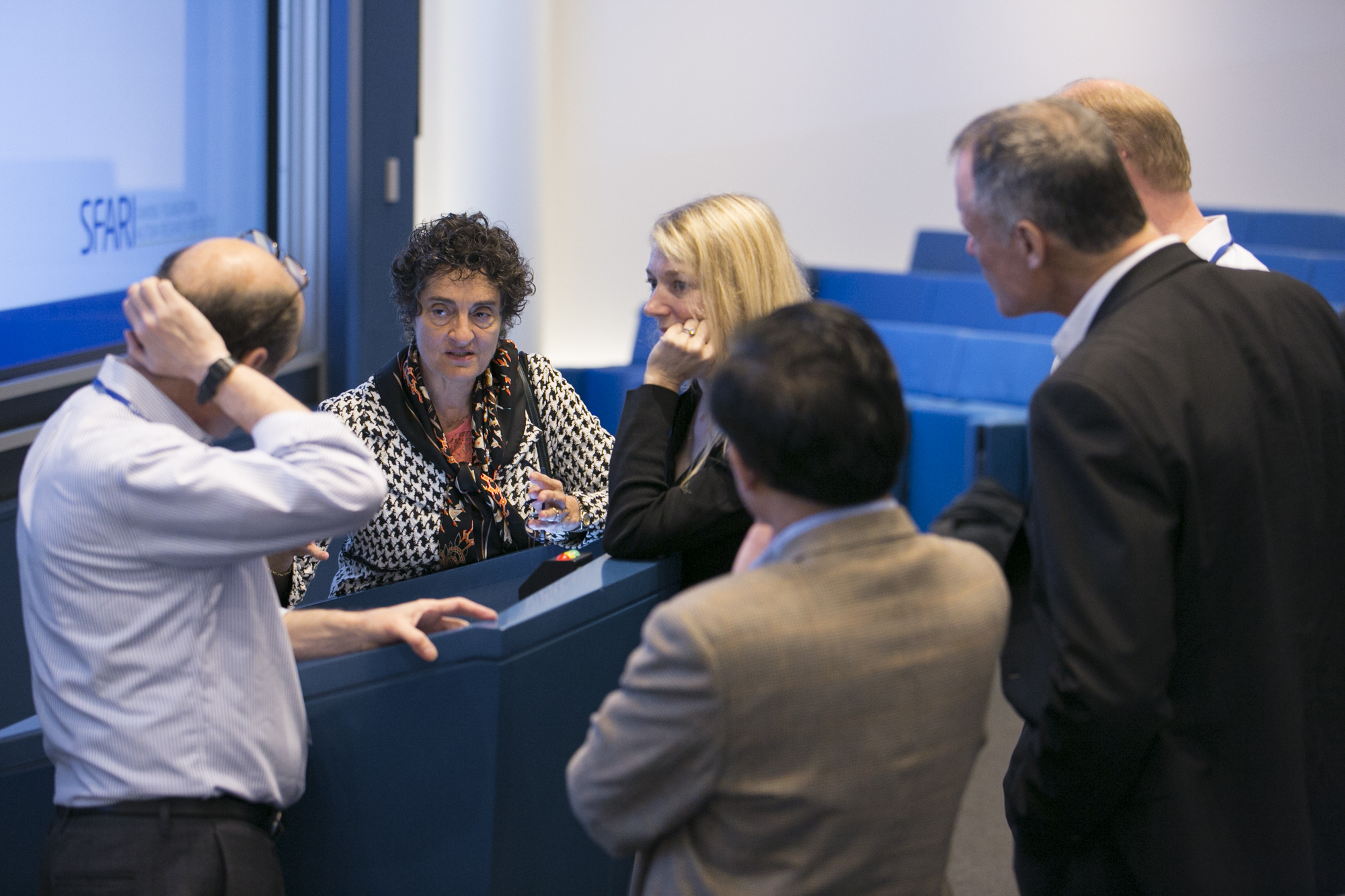 Six people standing around a lectern together