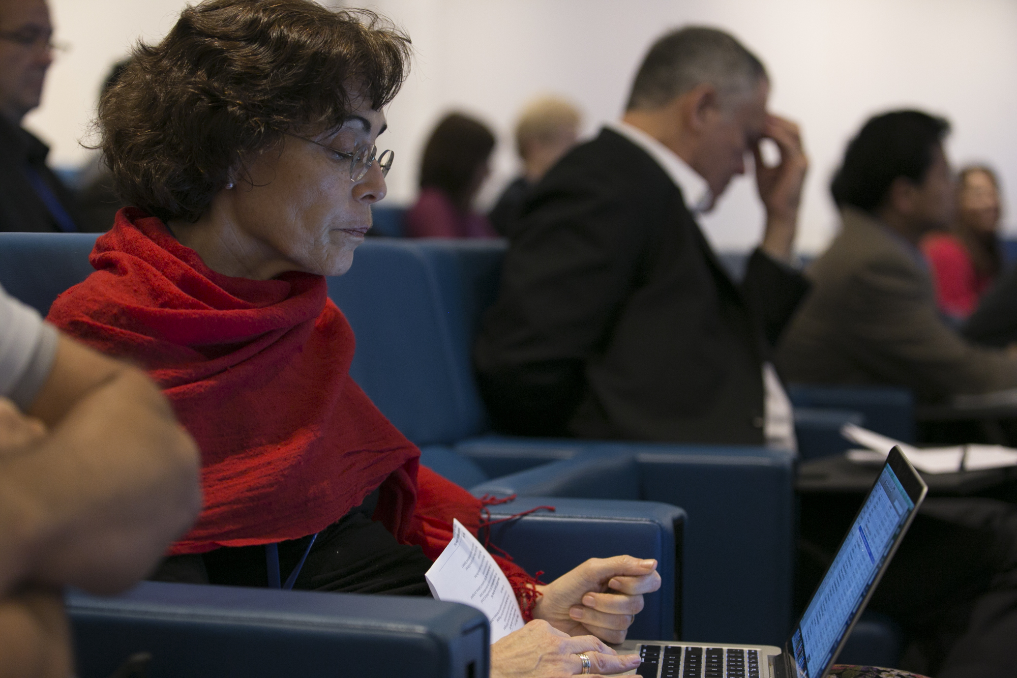 Woman sitting in a lecture hall while on her laptop