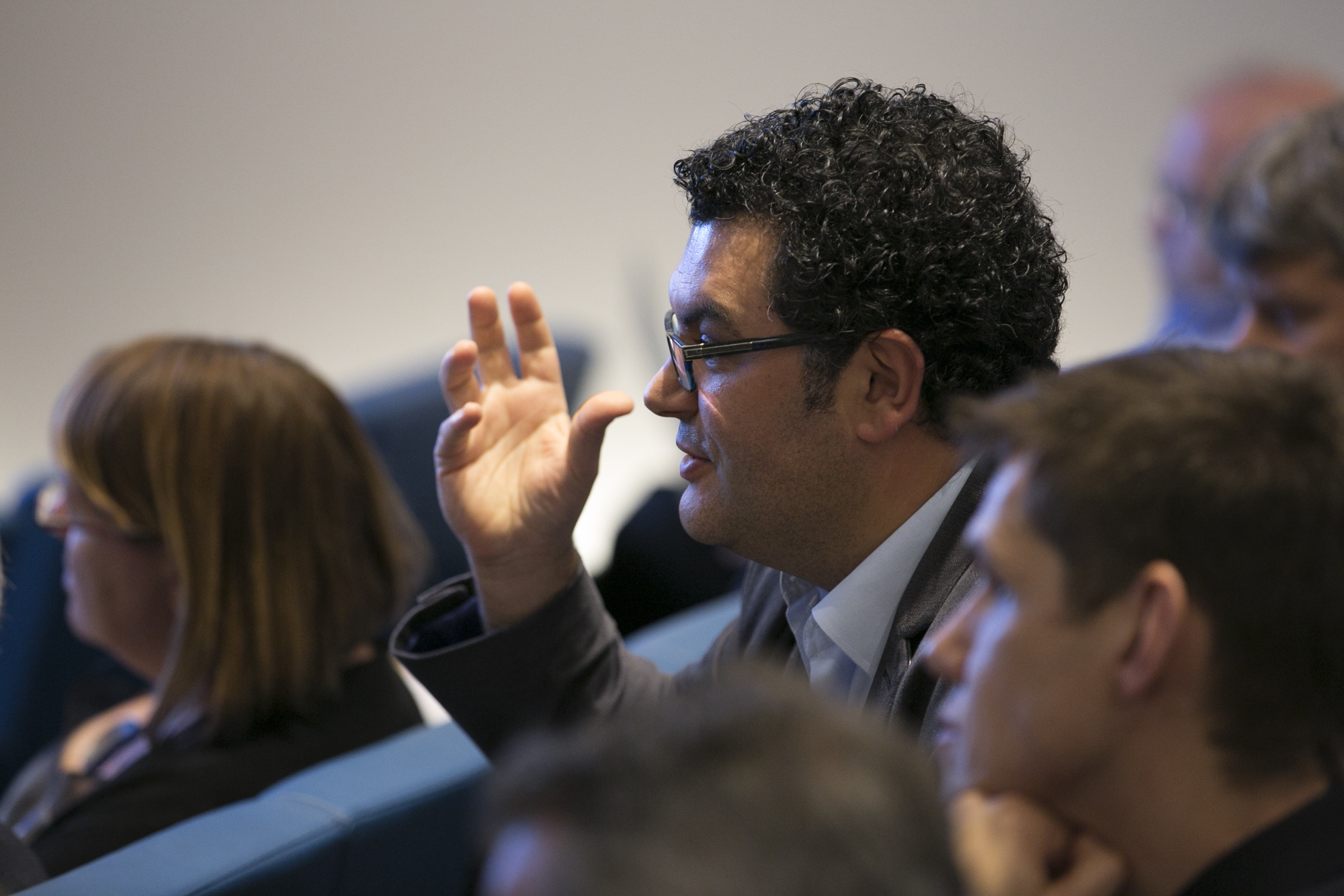 Man sitting and talking as he gesticulates with his hand