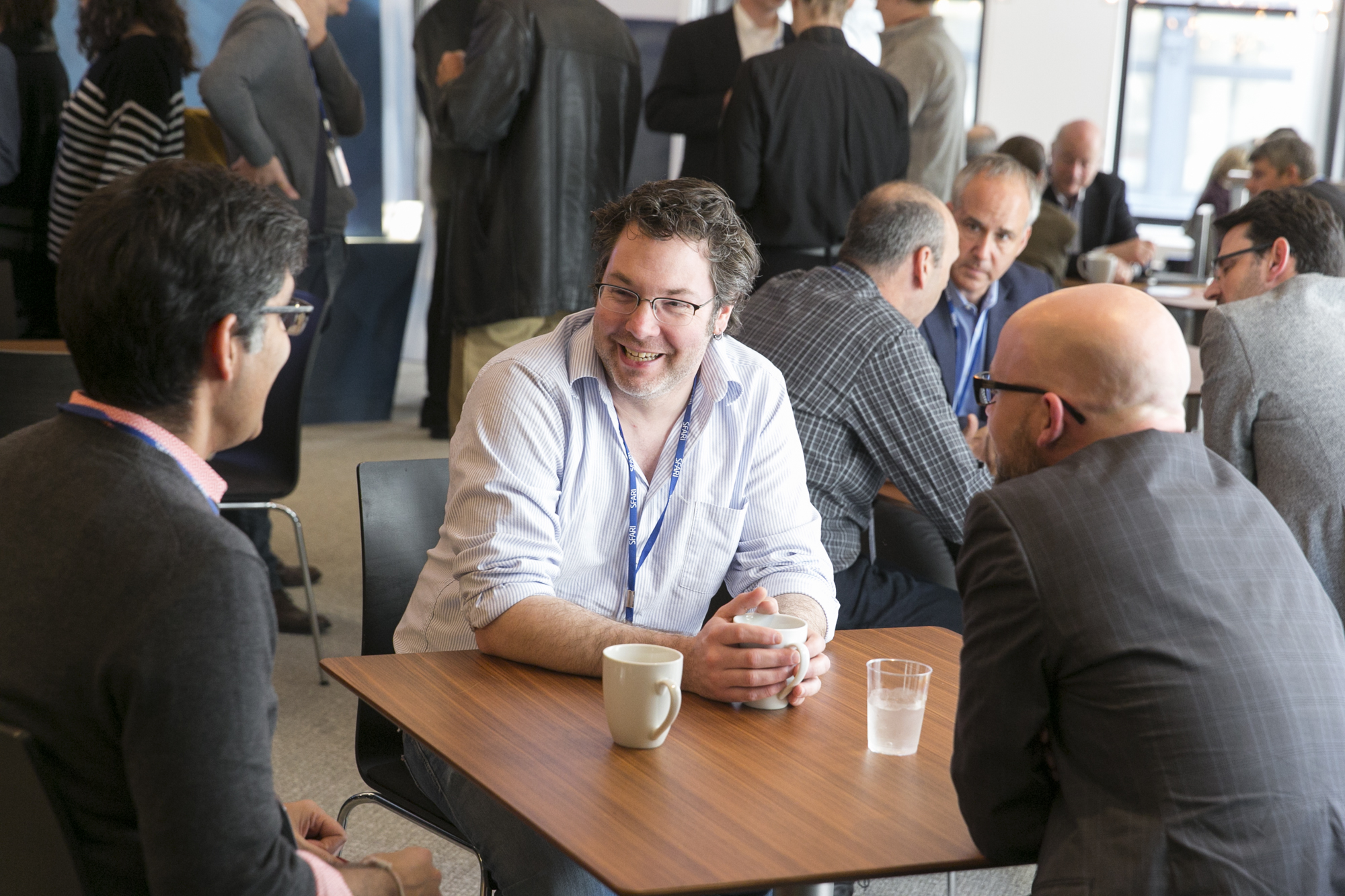Three men sitting at a table and talking