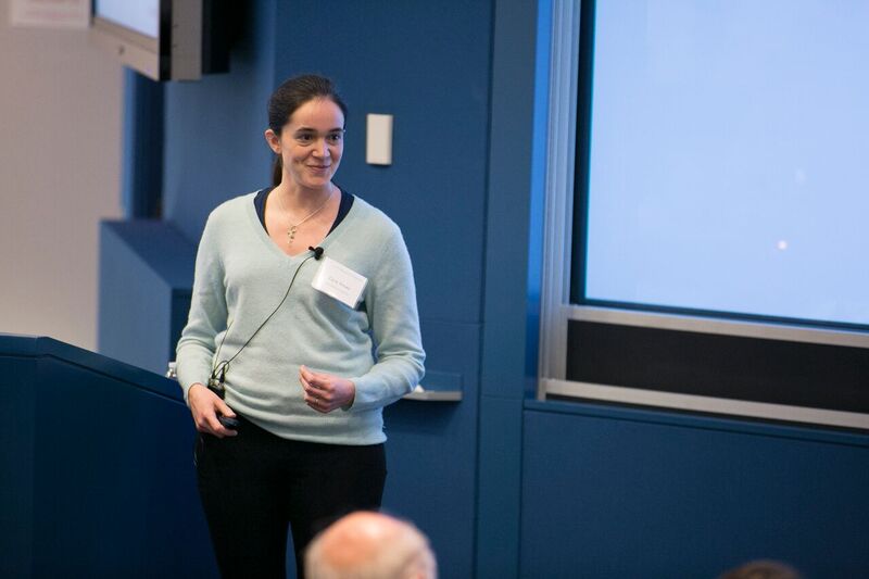 Katherine Cora Ames standing next to a lectern, presenting a slideshow