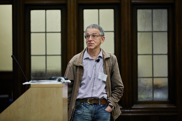 Man standing next to a lectern with a hand in his pocket