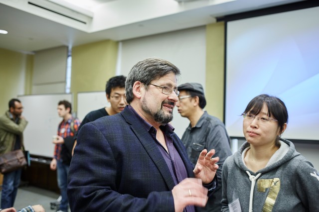 Woman and man standing and talking in lecture hall