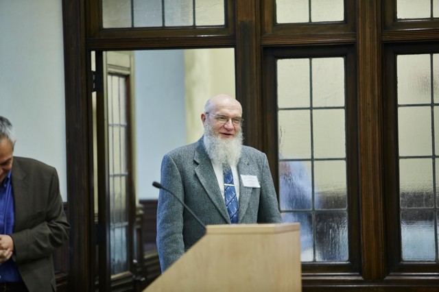 Man entering a room standing behind a lectern