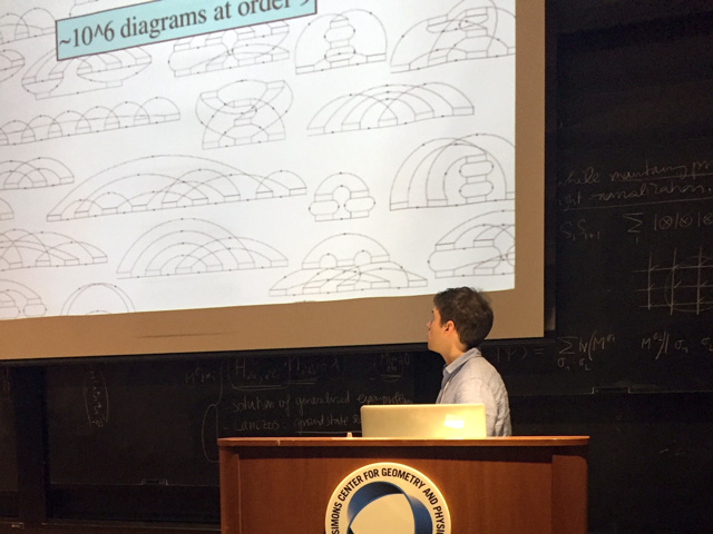 Man standing behind lectern while presenting a slideshow that says ~10^6 diagrams at order