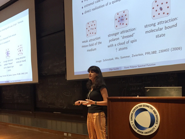 Woman standing while presenting a slideshow that says: 