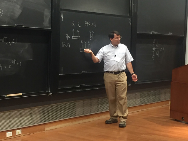 Man pointing to math on multilayered chalkboard