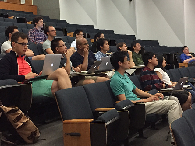 Half-filled lecture room of people looking forward