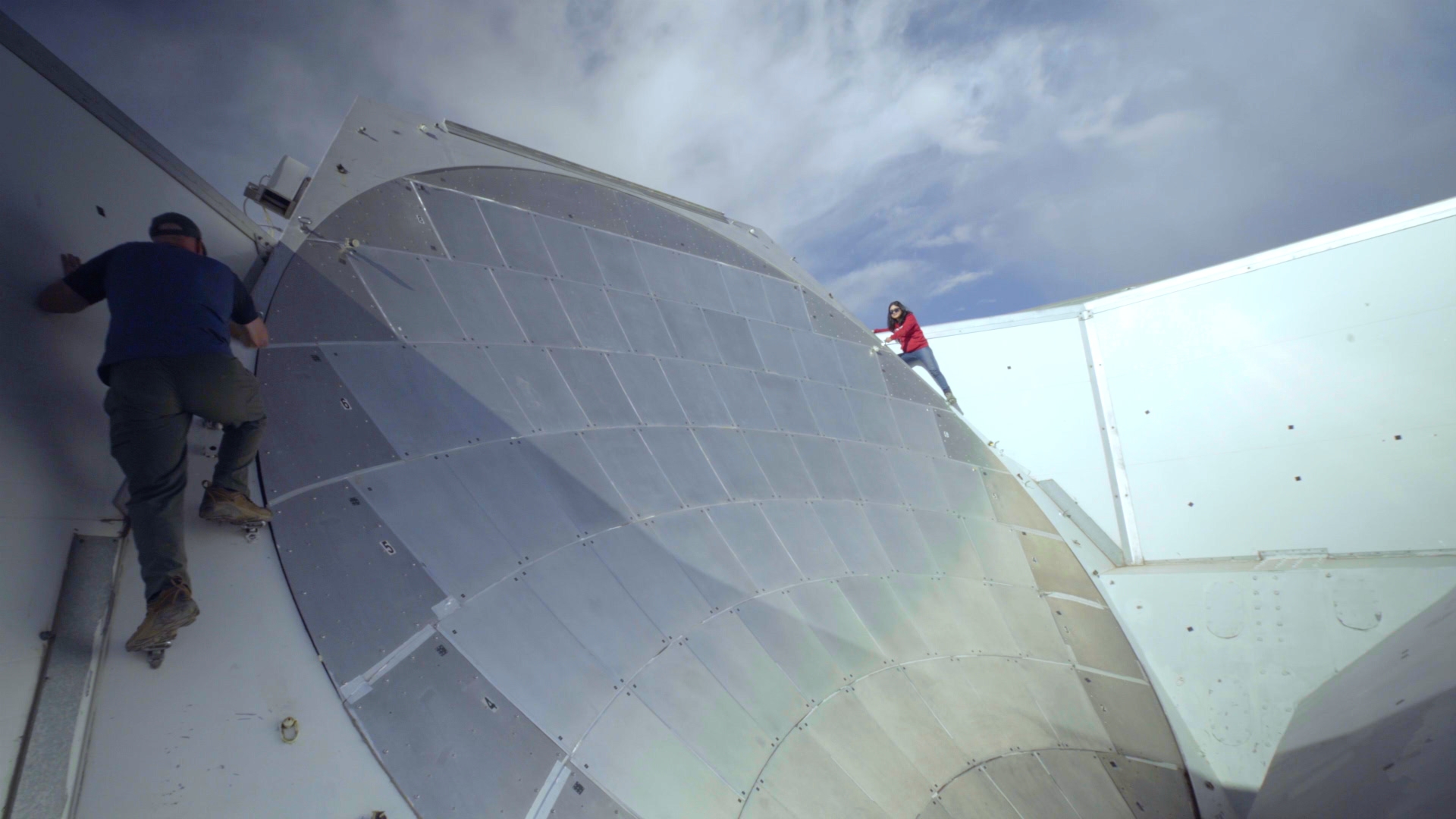 Two men working on a satellite