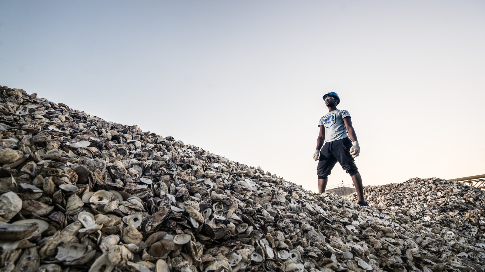 A man standing on hills made of empty oyster shells