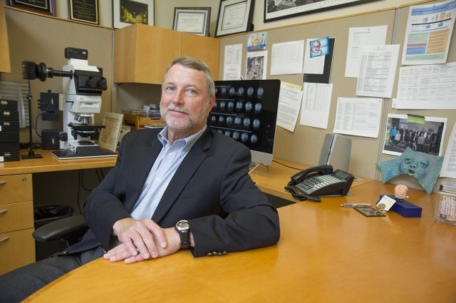 David Amaral sitting in a chair and leaning on a desk