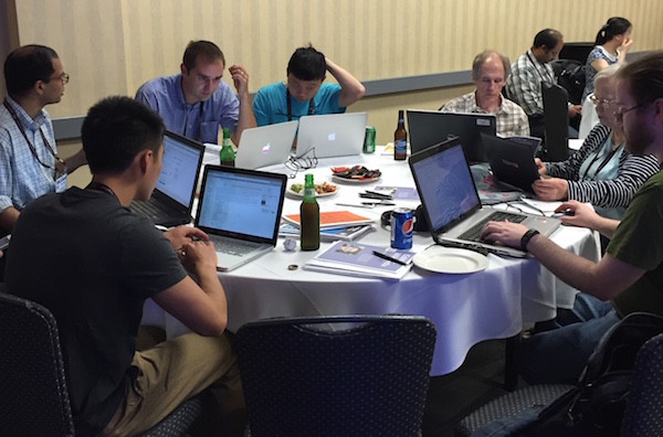 Group leader Amar Vutha (left, wearing lanyard) works with his team to edit pages on optical lattices and quantum optics