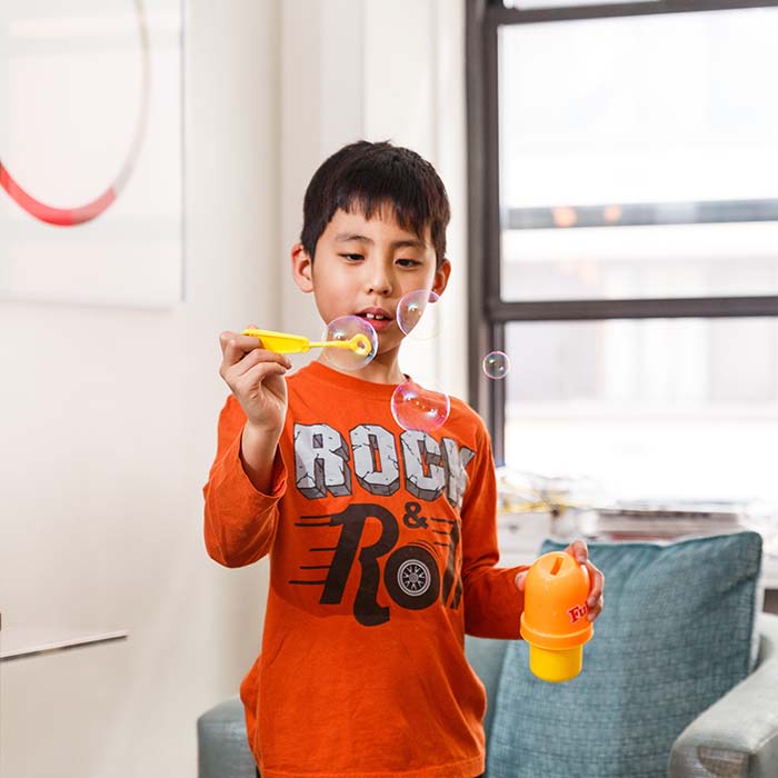 A young boy plays with bubbles