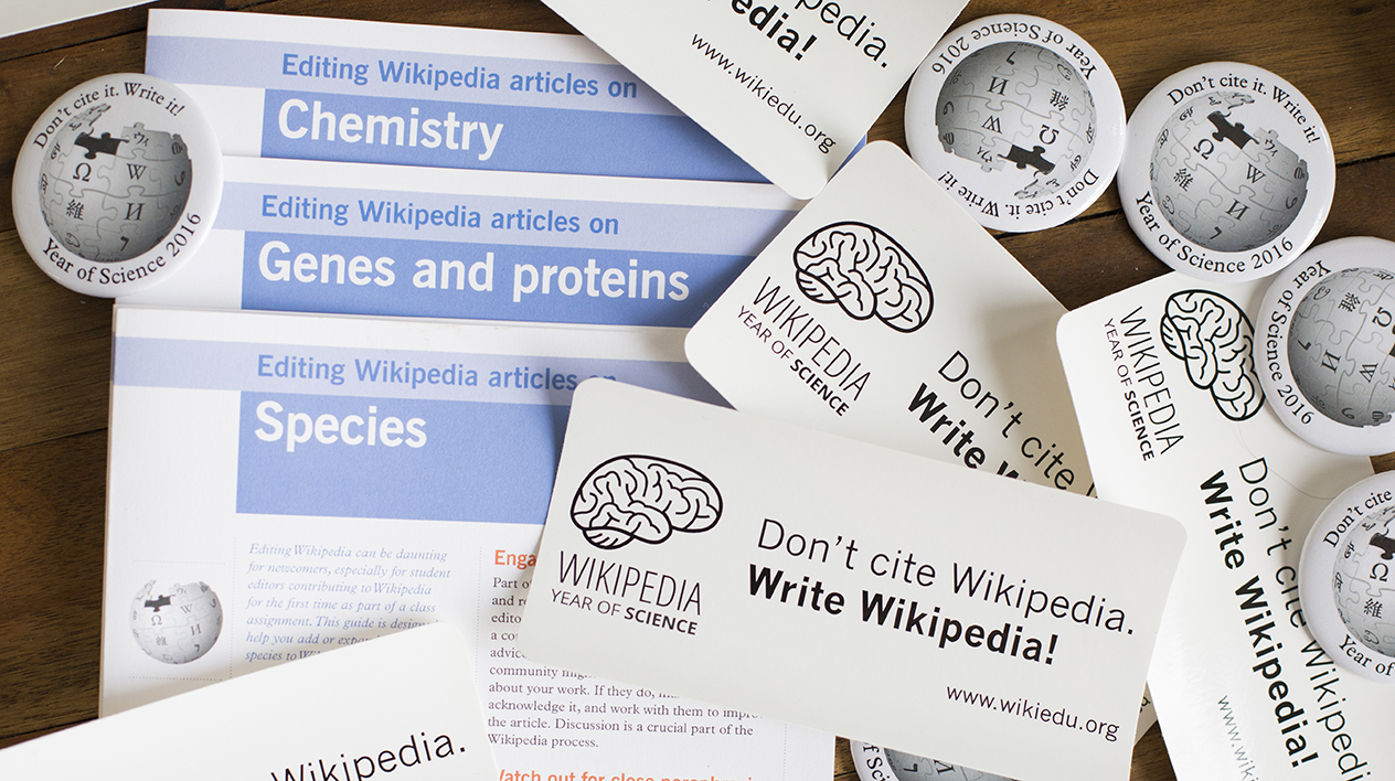 Wikipedia Year of Science swag in a pile: fliers, signs and pins