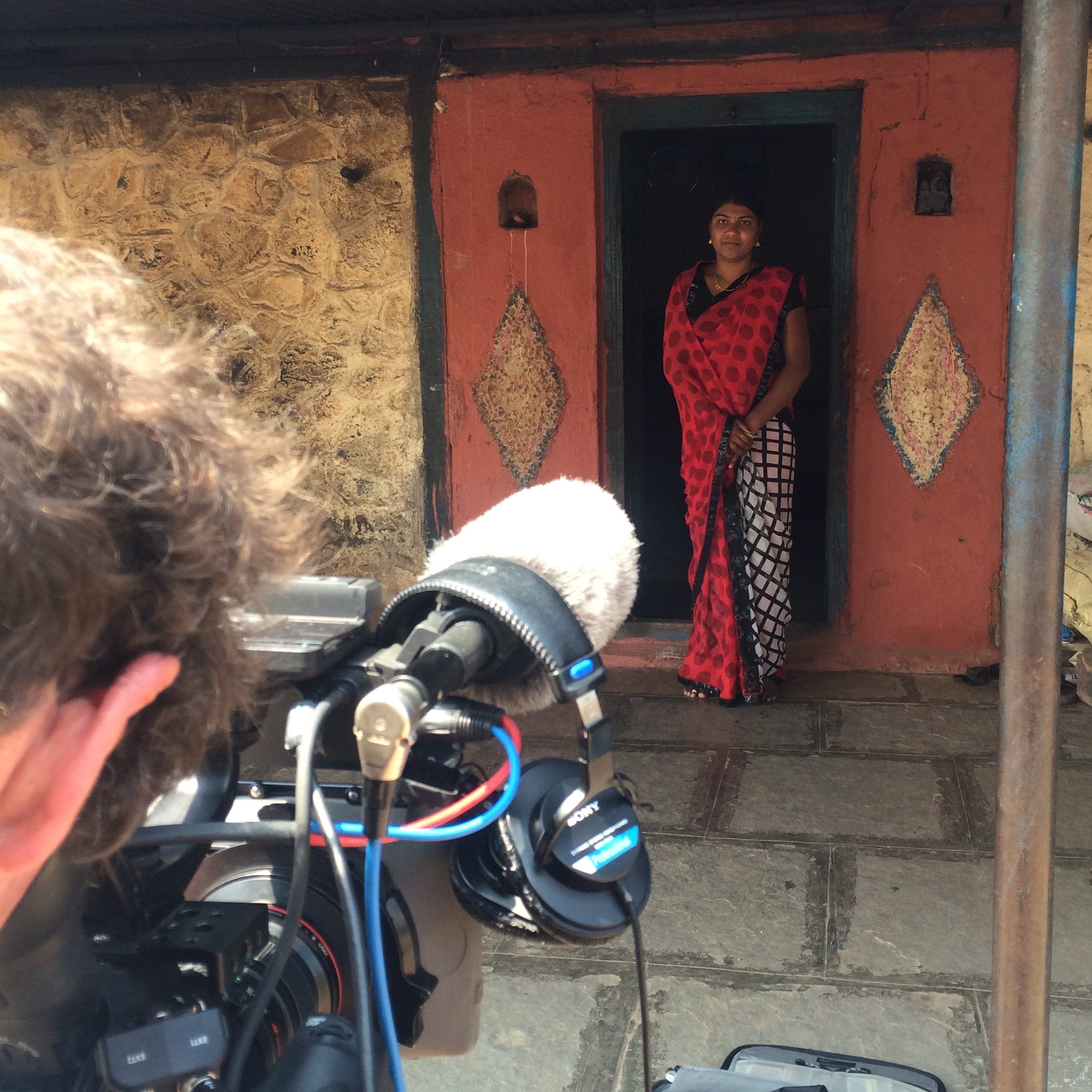 A Vice videographer filming Pooja standing outside her house in Pune, India