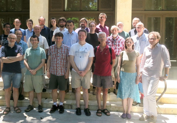 Group of 23 people standing and posing on stairs in front of a building