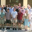 Group of 23 people standing and posing on stairs in front of a building