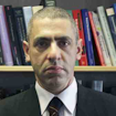 Peter Dayan in front of a bookshelf