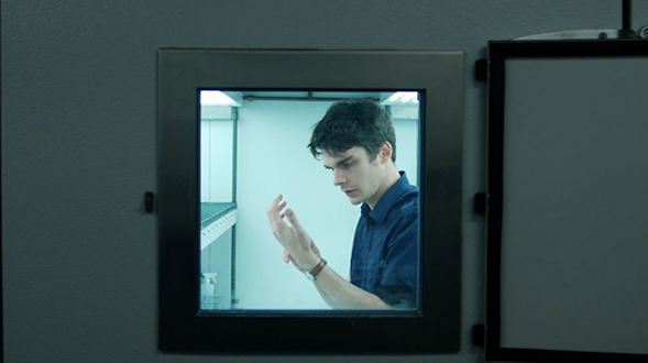 Still image from movie Symbiont. Window looks at man looking at his hands