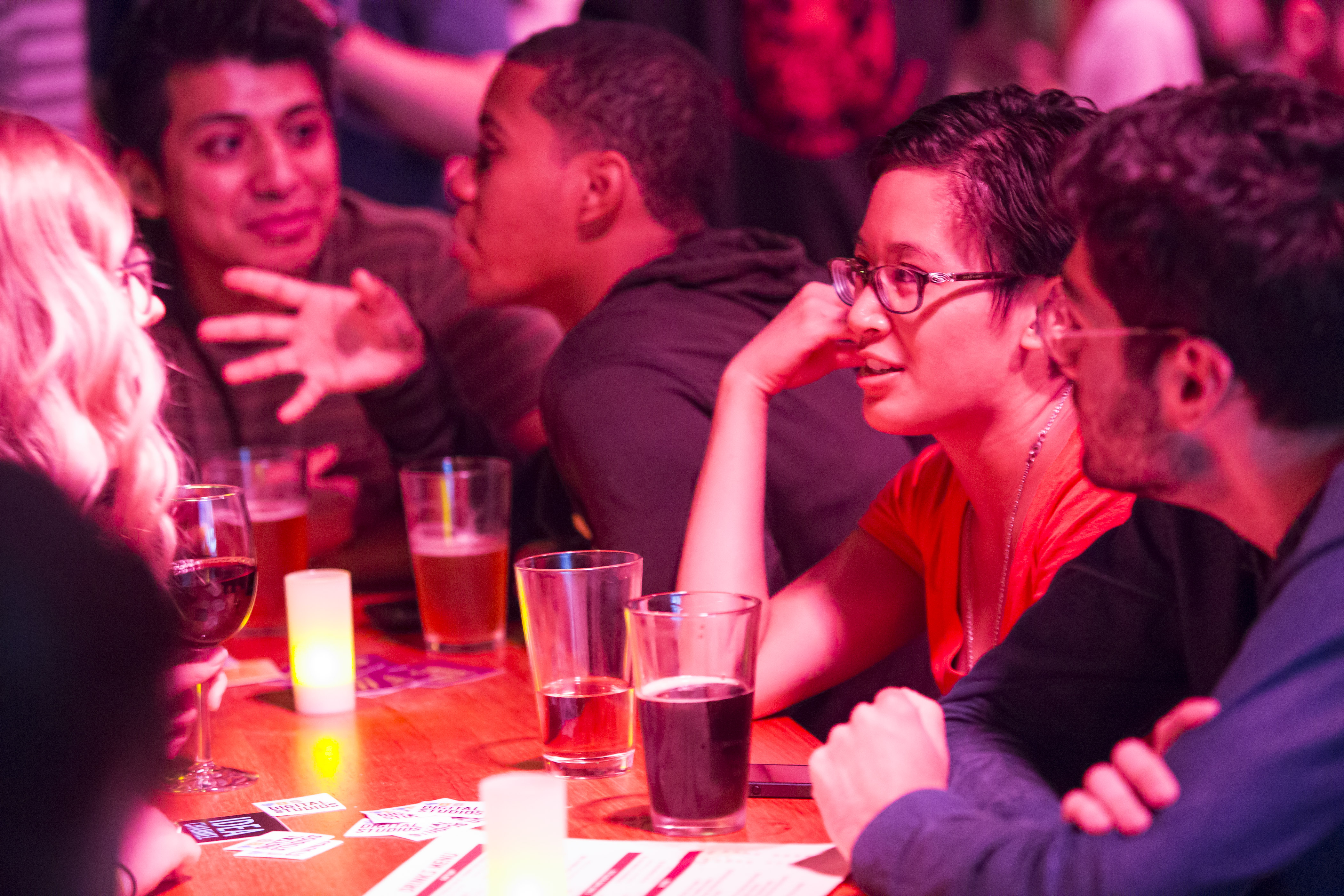 People talk at bench tables over drinks