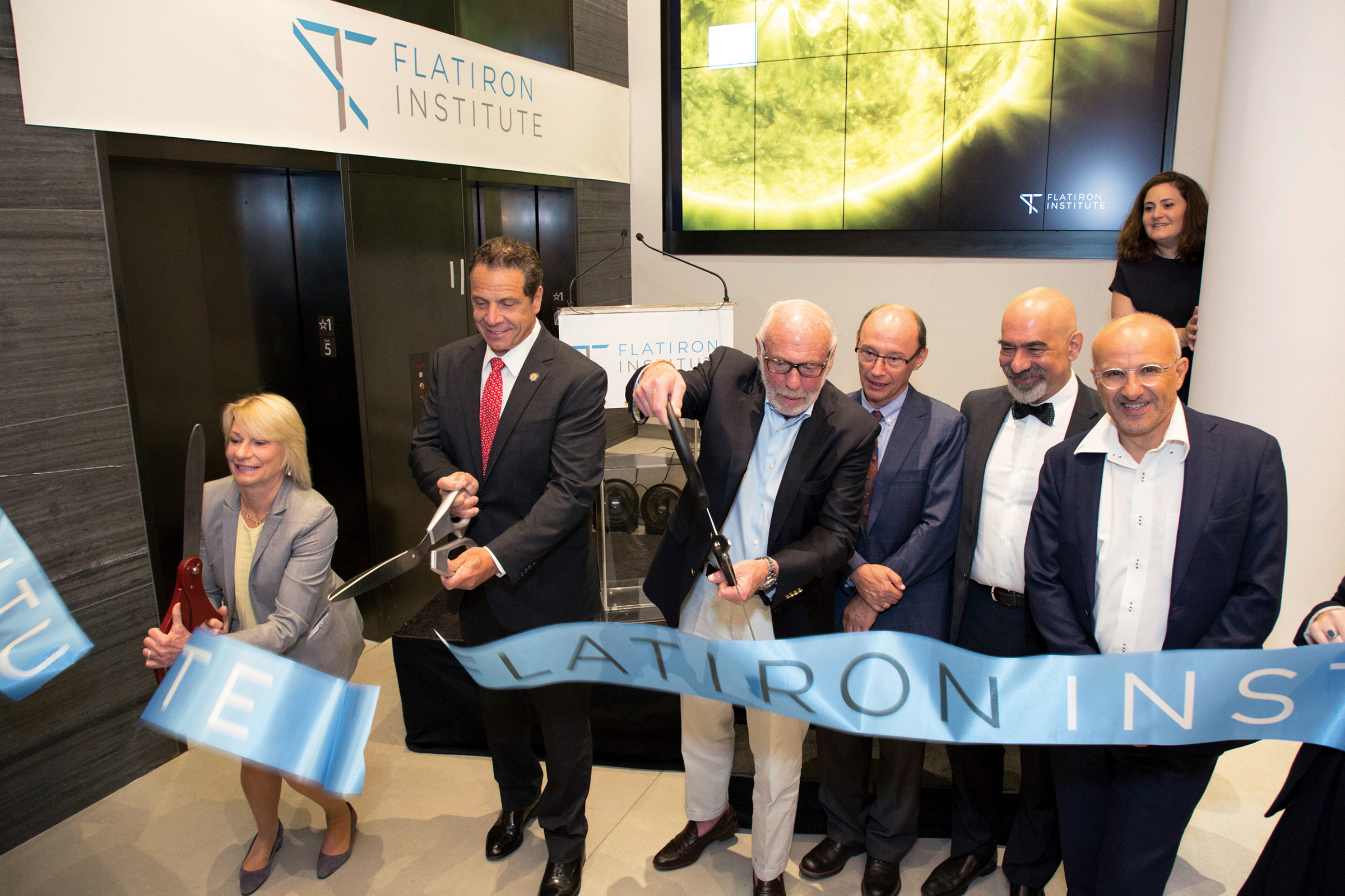 Marilyn Simons, Gov. Andrew Cuomo and Jim Simons cut the ribbon during the Flatiron Institute’s inauguration ceremony. Also pictured, from left to right, are center leaders Leslie Greengard, David Spergel and Antoine Georges.