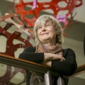 Duke mathematician and professor of electrical and computer engineering Ingrid Daubechies in the Fitzpatrick Center for Interdisciplinary Engineering Medicine and Applied Sciences (F-CIEMAS) atrium with two of the metallic orb sculptures that are part of installation by designer George Hart that were commissioned by Daubechies
