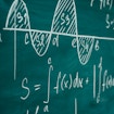 A photograph of a series of complex equations written in chalk on a chalkboard.