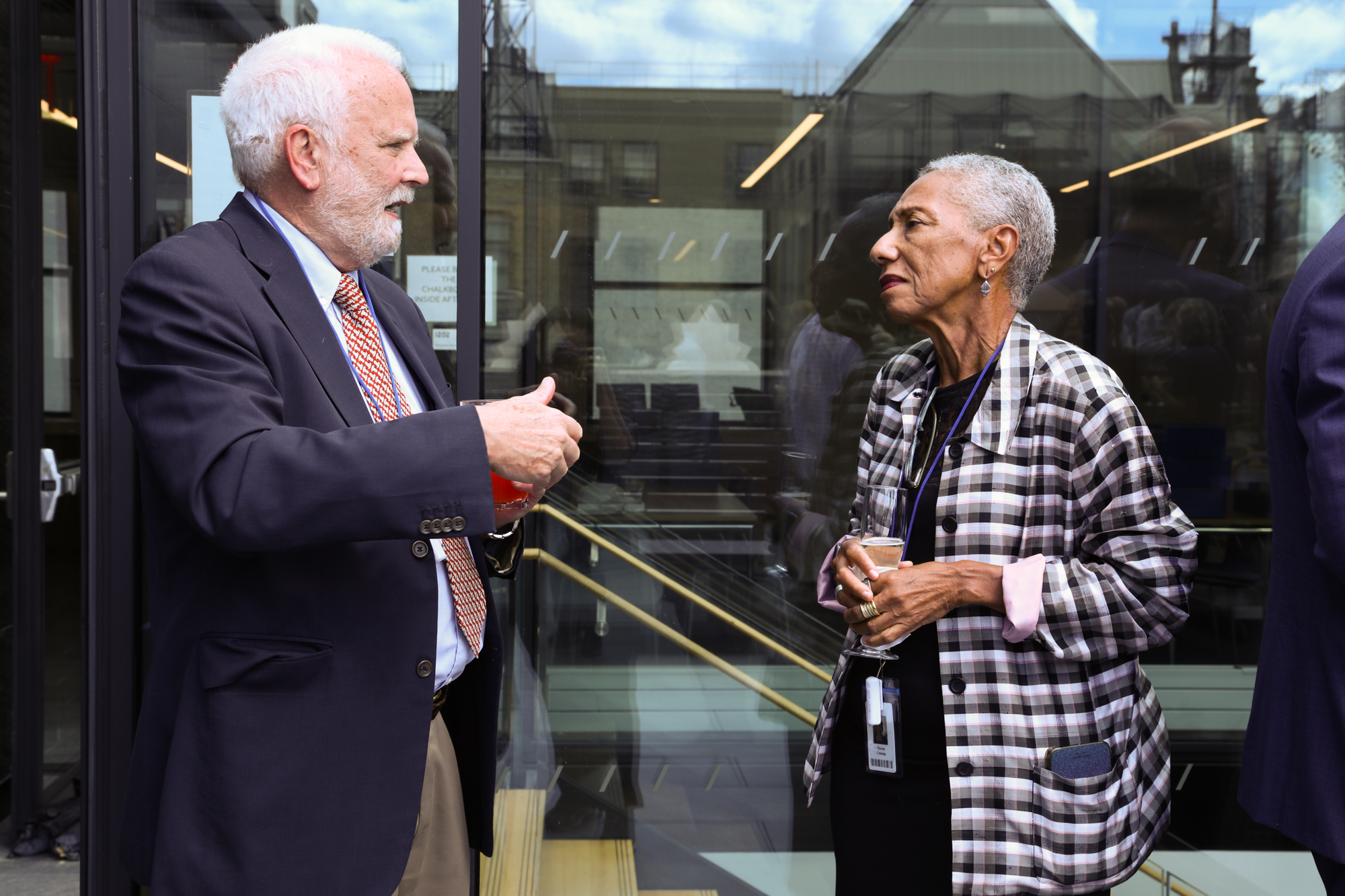 A photograph of one man and one woman talking in an outdoor space.