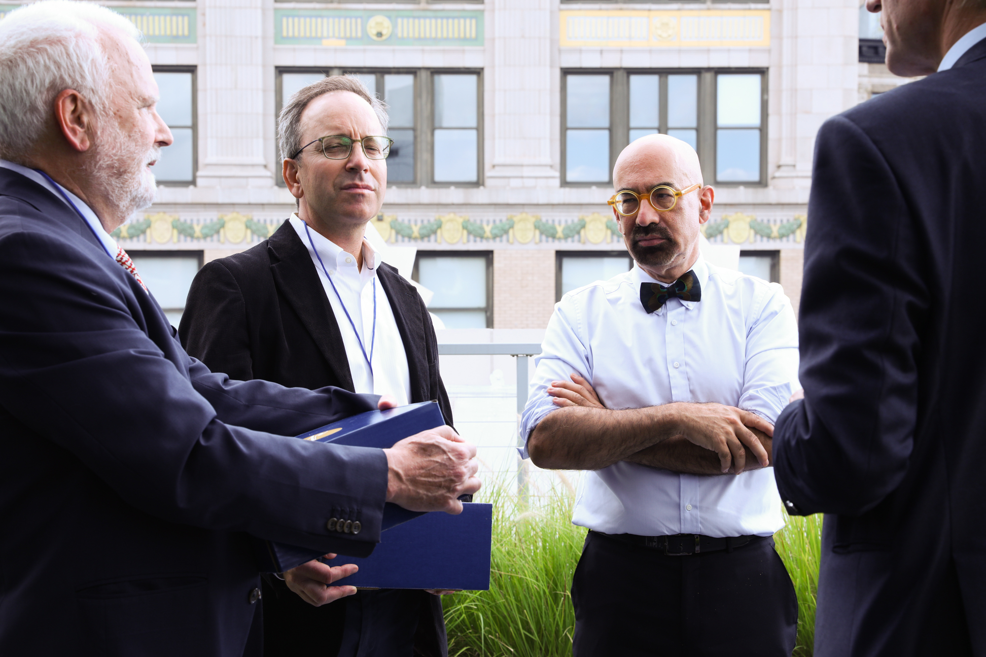 A photograph of four men in an outdoor space.
