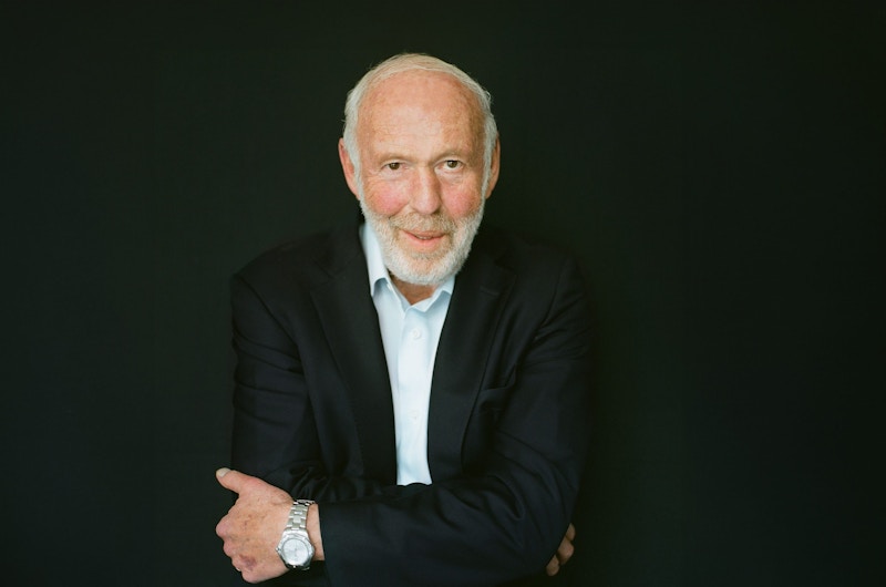A photo of Jim Simons crossing his arms and smiling.