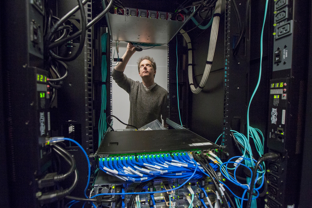 Ian fisk standing in the middle of a computer rack