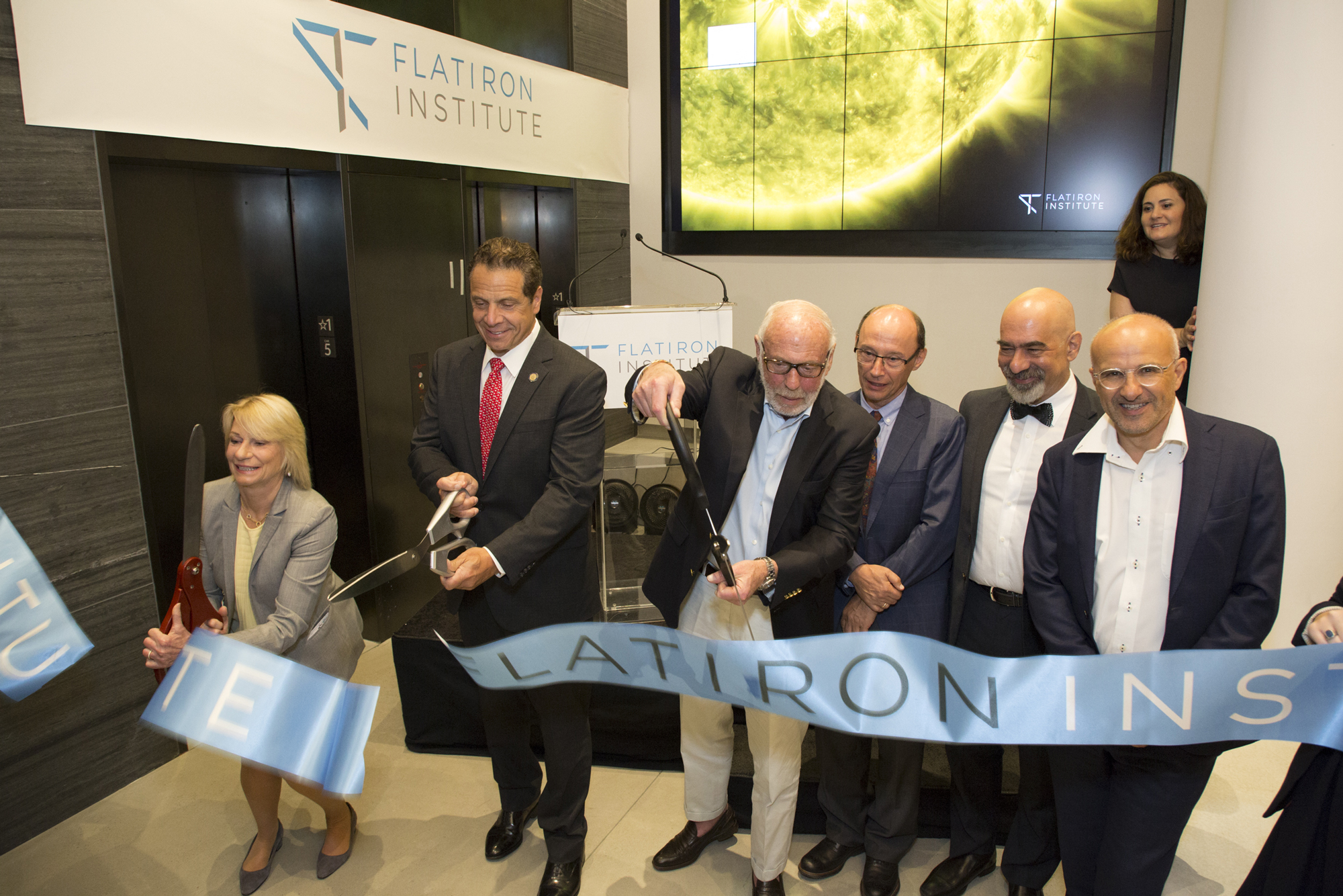 Marilyn Simons, New York Gov. Andrew Cuomo and Jim Simons cut the ribbon during the Flatiron Institute’s dedication ceremony. Joining them, from left, were center directors Leslie Greengard, David Spergel and Antoine Georges.